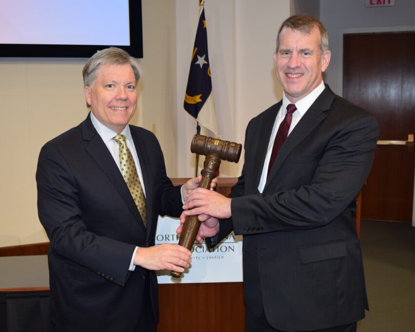 Mark Holt and Jon Heyl stand holding the gavel.