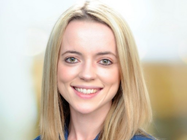 Katie Riddle, a white woman with blond hair, wears a blue blouse.