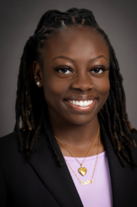 Destiny, a Black woman with black hair, wears a pink blouse and black jacket.