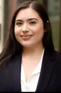 Jessica, a Hispanic/Latina woman, wears a white shirt and black jacket.
