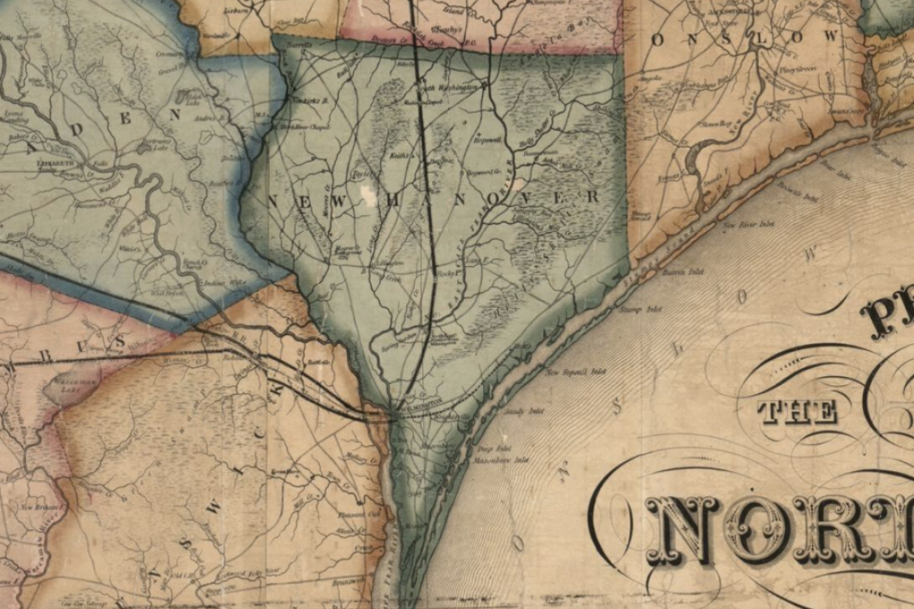 An ivory map shows the outline of New Hanover in a grey-green. New Hanover is square on the top with a triangular tip at the bottom.