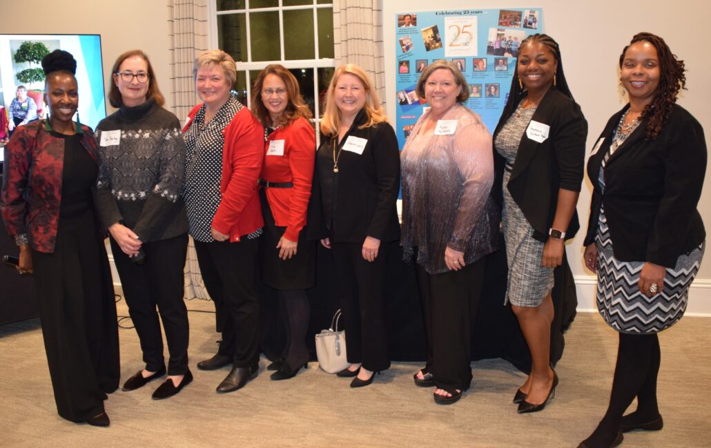 Current Paralegal Division Chair Lakisha Chichester, a Black woman with black hair, wears a black shirt and pants and a red jacket. She stands alongside former Paralegal Division chairs who are all pictured smiling.