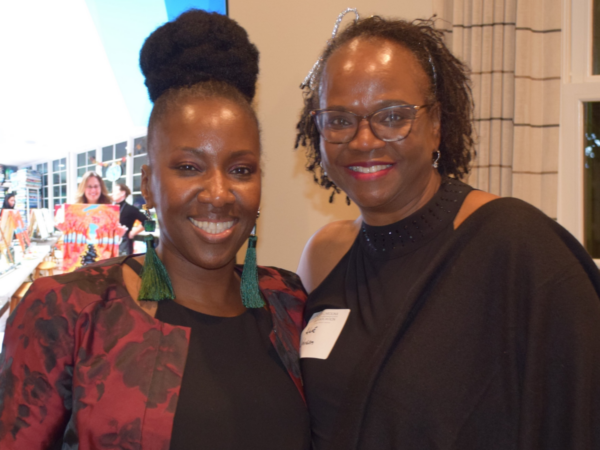 Lakisha Chichester, Paralegal Division Chair, is a Black woman with black hair. She is wearing a black blouse and red jacket. She is pictured with a Black woman who also has black hair and is wearing a black blouse.