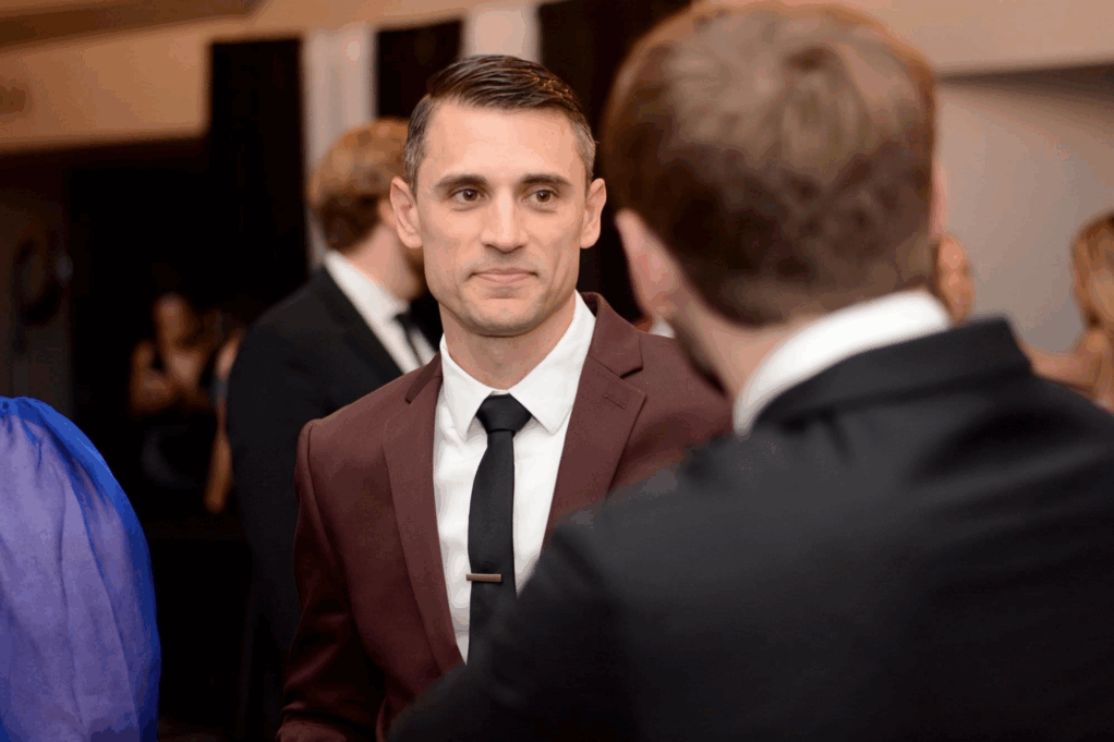 Bowyer, a white man with brown hair, wears a white shirt, brown tie and brown suit. 